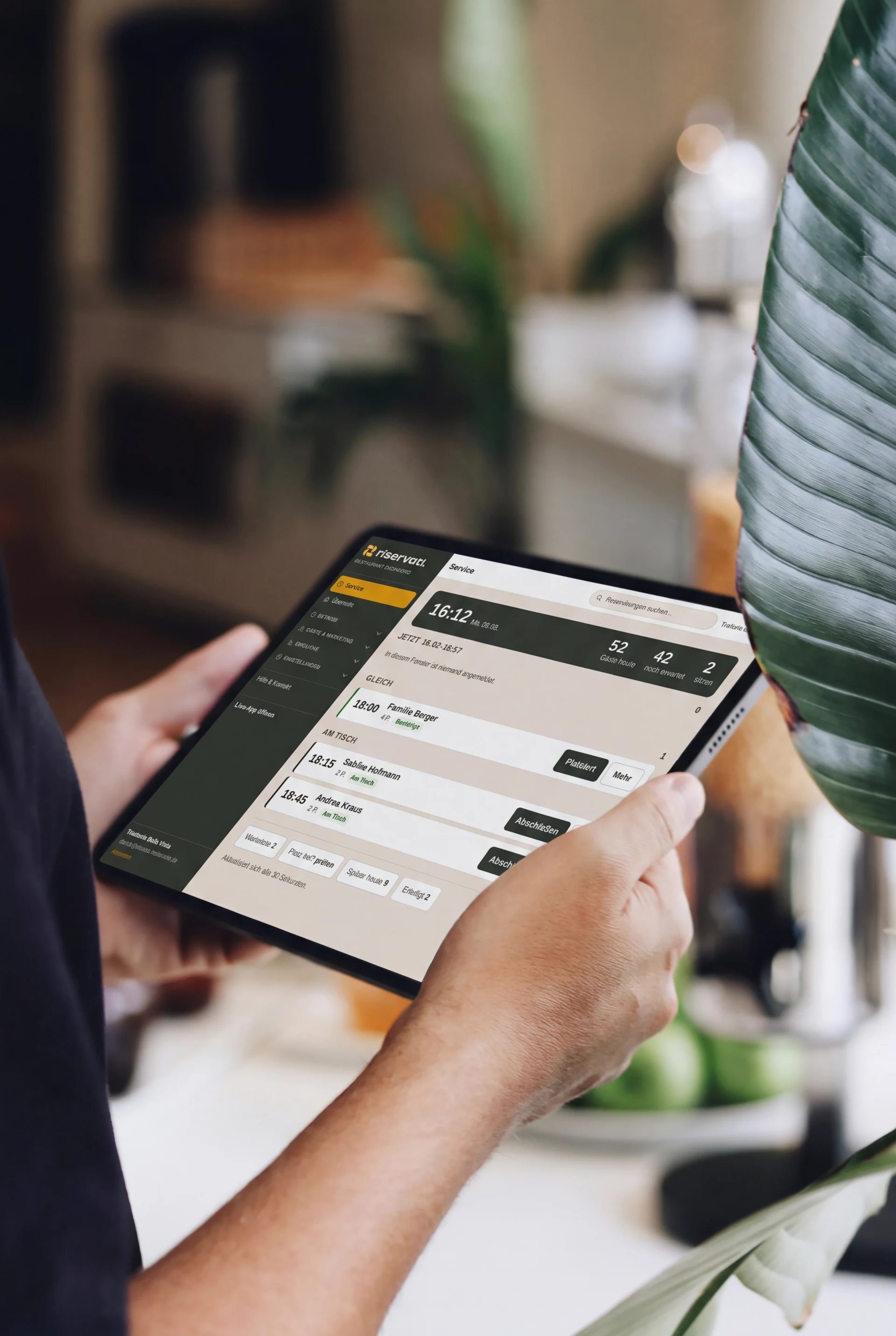 Riservati auf dem Tablet in der Hand des Wirts